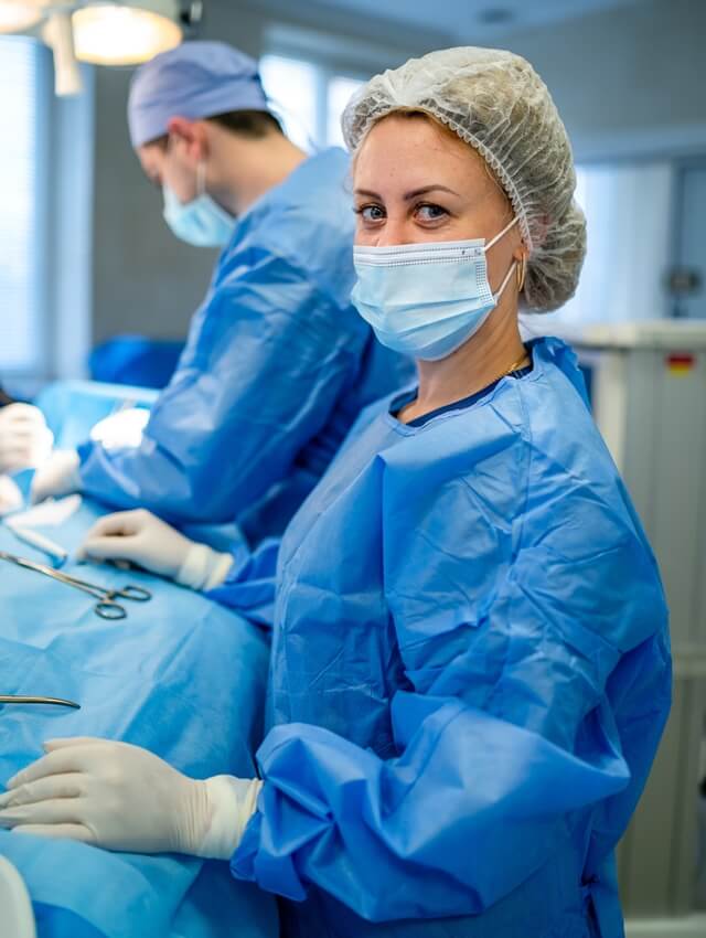 Lady-doctor-wearing-blue-non-woven-medical-gown-cap-mask 