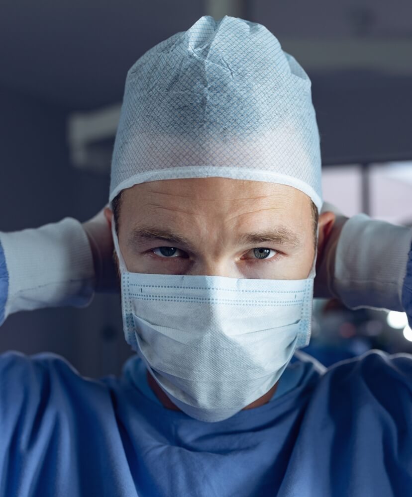A doctor is wearing blue non woven medical products such as non-woven gown, cap and mask